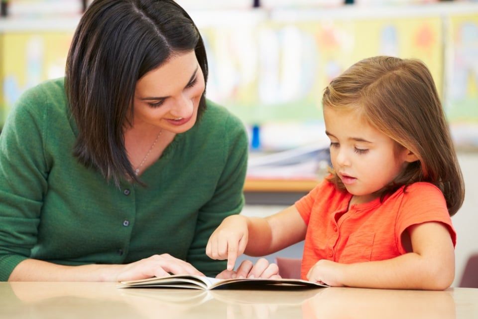 Photo of a child and a teacher